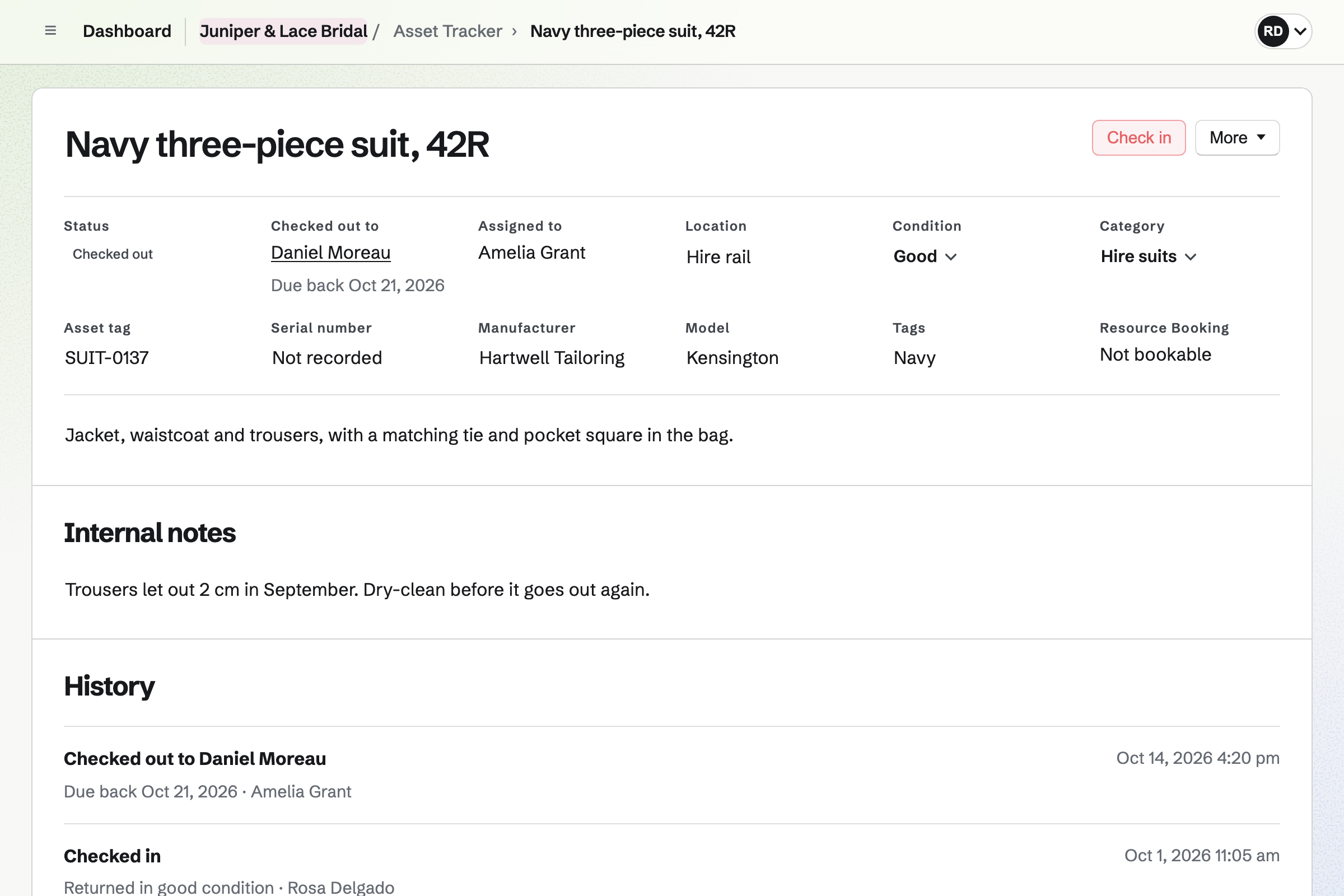 A navy hire suit in Juniper & Lace Bridal’s Asset Tracker, checked out to Daniel Moreau and due back in two days, with its condition and the history of earlier hires.